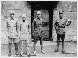Four soldiers pose for a photograph by a door