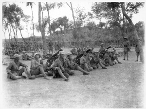 Eighth Route Army soldiers sitting on the ground with three heavy machine guns