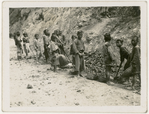 Children shovelling excavated stones into baskets to make roads