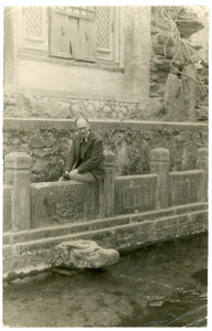 Michael Lindsay (林迈可) looking at a stone dragon head water spout (dragon-headed gargoyle)
