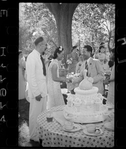 Hsiao Li Lindsay (李效黎) shaking hands with a guest beside the cake, at the Lindsay's wedding party at Yenching University (燕京大學), Beijing (北京)