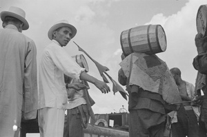 An overseer with a tally stick, and stevedores loading barrels, Shanghai