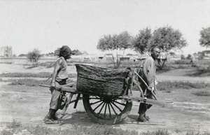 Two men with a heavy duty wheelbarrow
